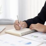 Poslovna osoba zapisuje bilješke uz financijske izvještaje i analizira porez na dobit.